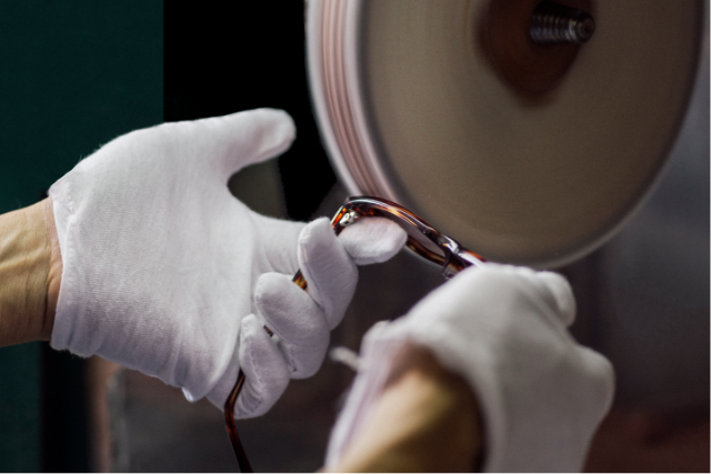 White-gloved hands polishing a metal frame.