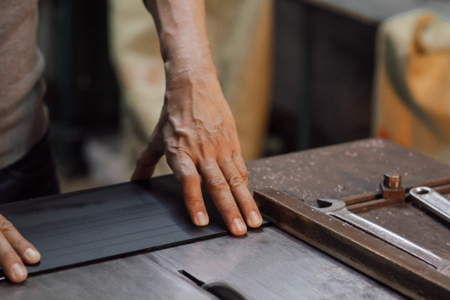 White-gloved hands polishing a metal frame.